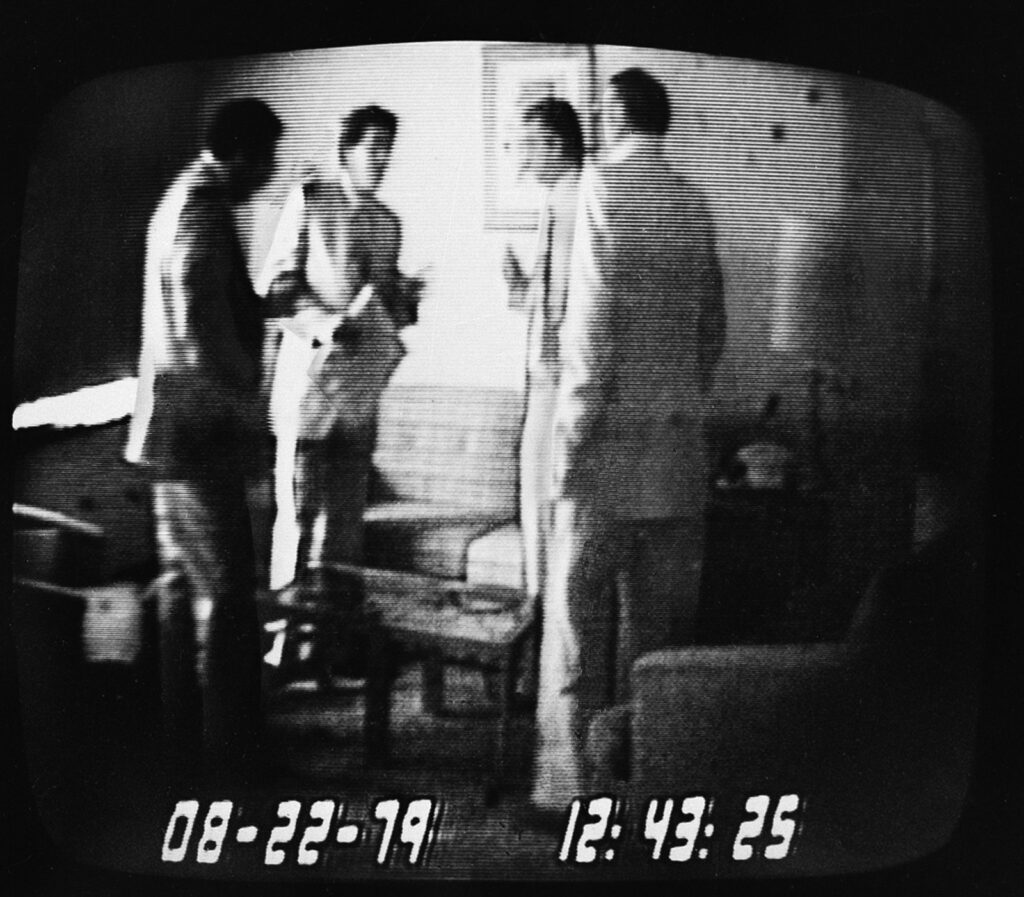 FBI surveillance video frame dated August 22, 1979 showing Rep. Michael Myers holding an envelope of cash with undercover agent Anthony Amoroso, Angelo Errichetti and Mel Weinberg