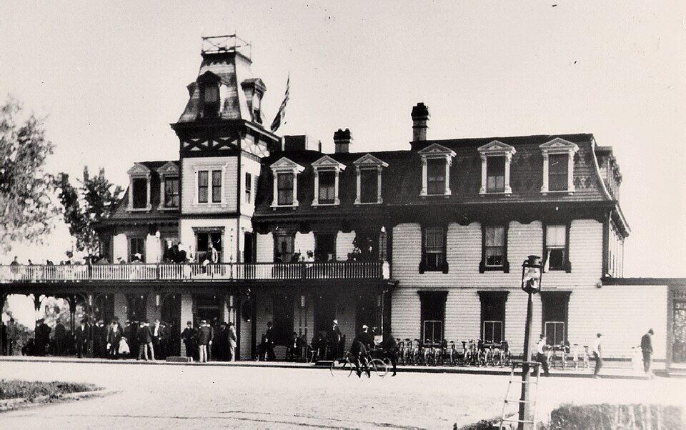 Cabin John Bridge Hotel, a Second Empire frame hotel with a tower and long porch, crowded with visitors and bicycles