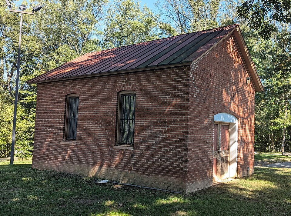 Small red brick gas house with a metal roof, the last surviving building of the Cabin John Bridge Hotel, in 2024