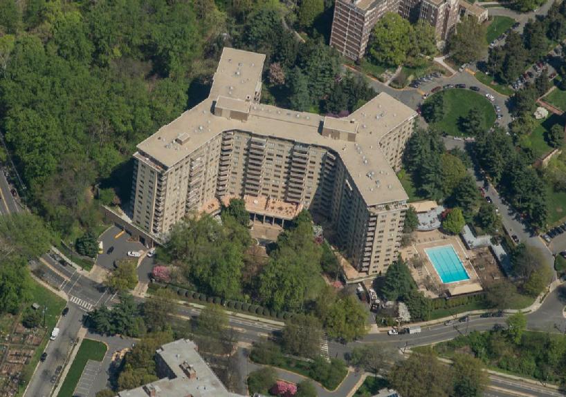 Oblique aerial view of The Colonnade, a 14-story buff brick New Formalist apartment building on New Mexico Avenue NW in Glover Park, looking north.