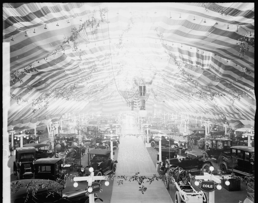 Rows of 1920s automobiles on display under striped bunting inside Convention Hall during the 1924 Washington Auto Show