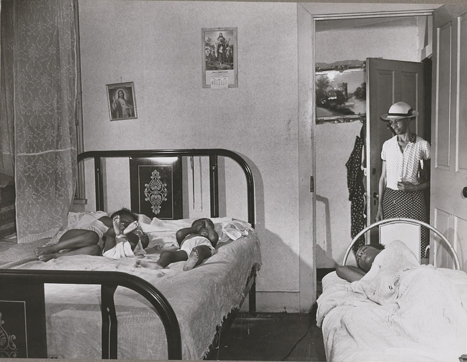 Ella Watson returning home from work at 2 a.m. while her grandchildren sleep, 1942
