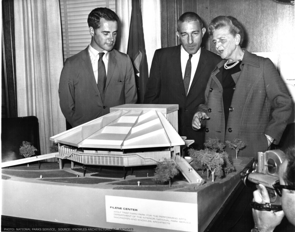 Two men and Catherine Filene Shouse look down at a tabletop architectural model of the Filene Center.