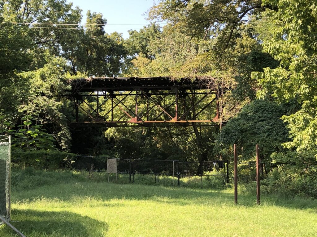 The Foundry Branch trestle behind a chain link fence in Glover-Archbold Park