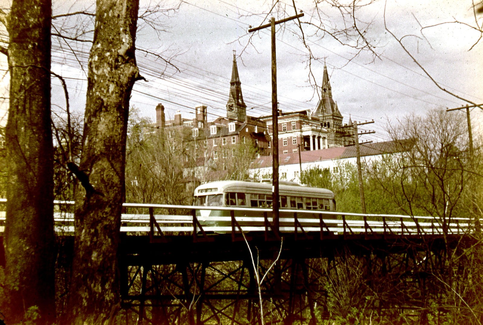 A D.C. streetcar crosses the Foundry Branch trestle with Georgetown University spires behind, 1948