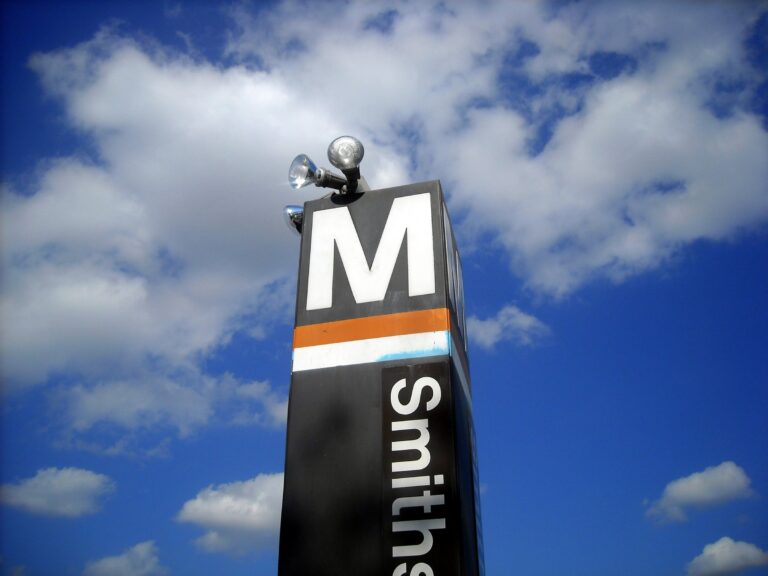 Brown Metro station pylon with the M logo against a blue sky