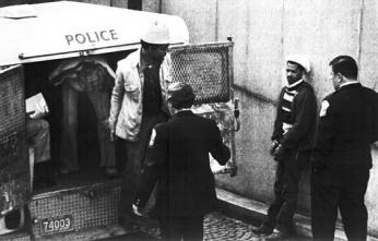 D.C. police officers standing at the open rear doors of a police van.