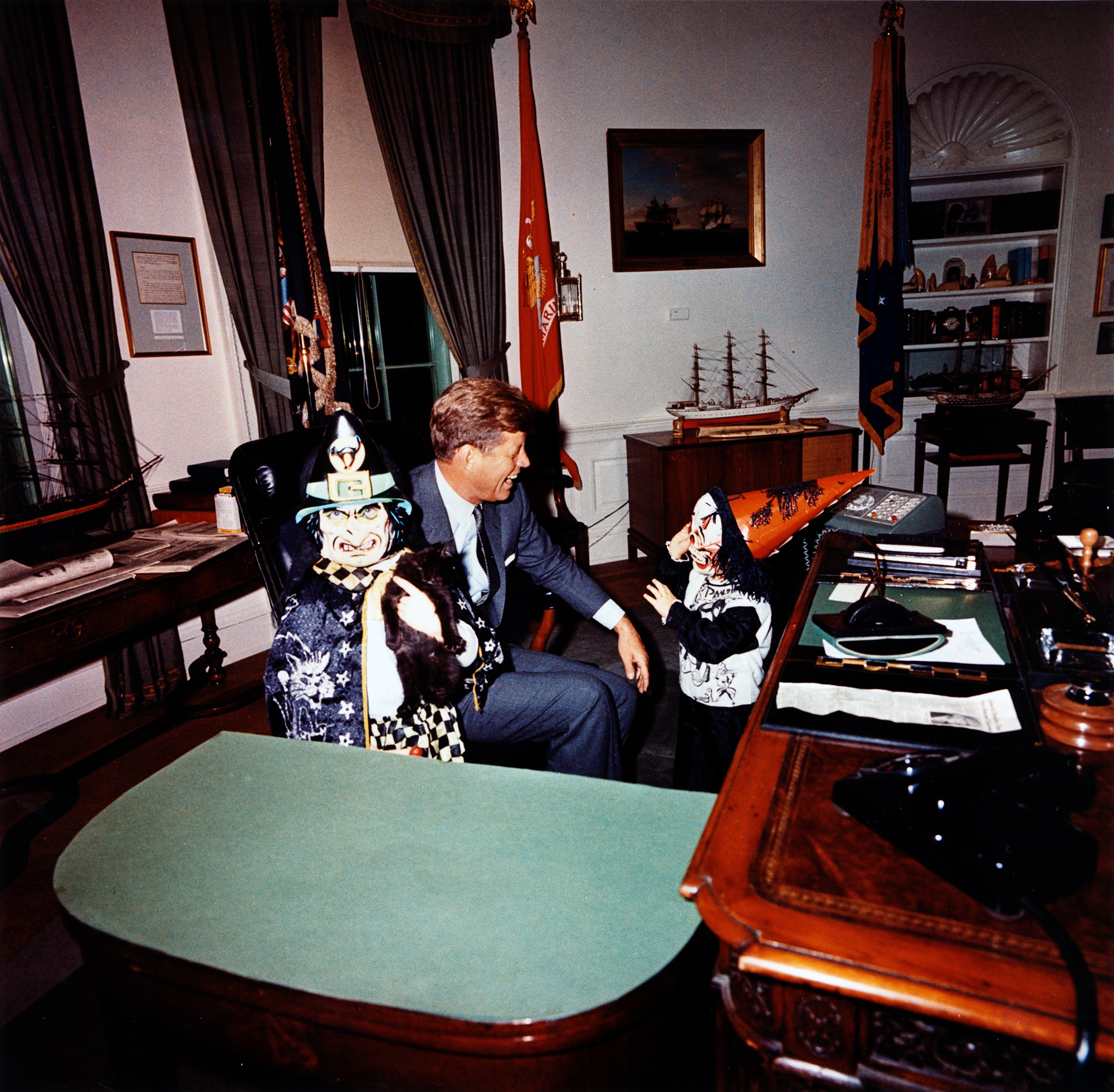 Caroline Kennedy and John F. Kennedy Jr. in Halloween costumes with President Kennedy in the Oval Office, 1963