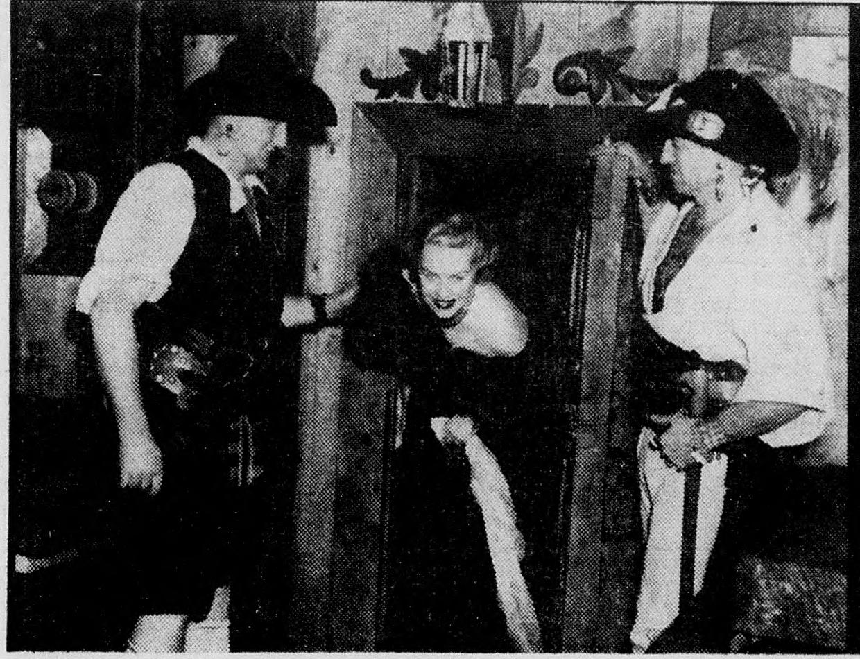Actress Madeleine Carroll being let out of the brig by costumed pirates at the Pirates' Den opening in Georgetown, February 1939