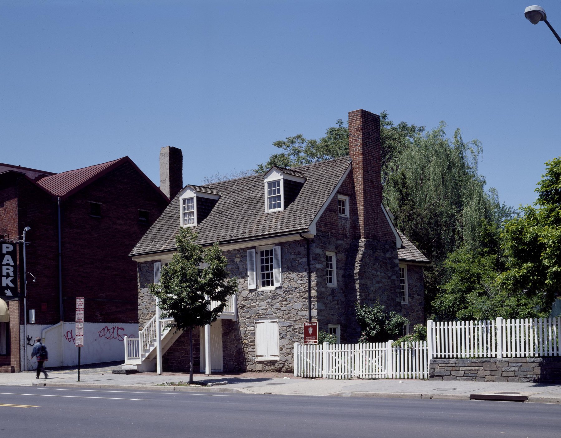 The Old Stone House, a small two-story fieldstone house with dormer windows and a tall chimney, on M Street in Georgetown