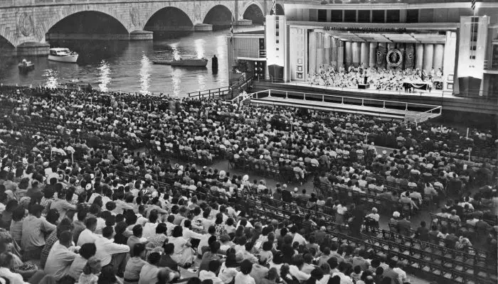 Crowd on Watergate steps watching performance on barge at edge of Potomac River (ca. 1956). Burdell Wright, Jr. Photograph Collection